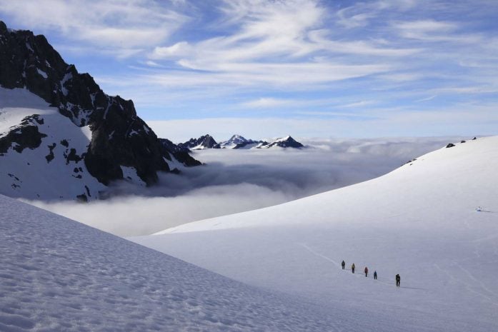 Hikers in a snowy Southern Alpine valley