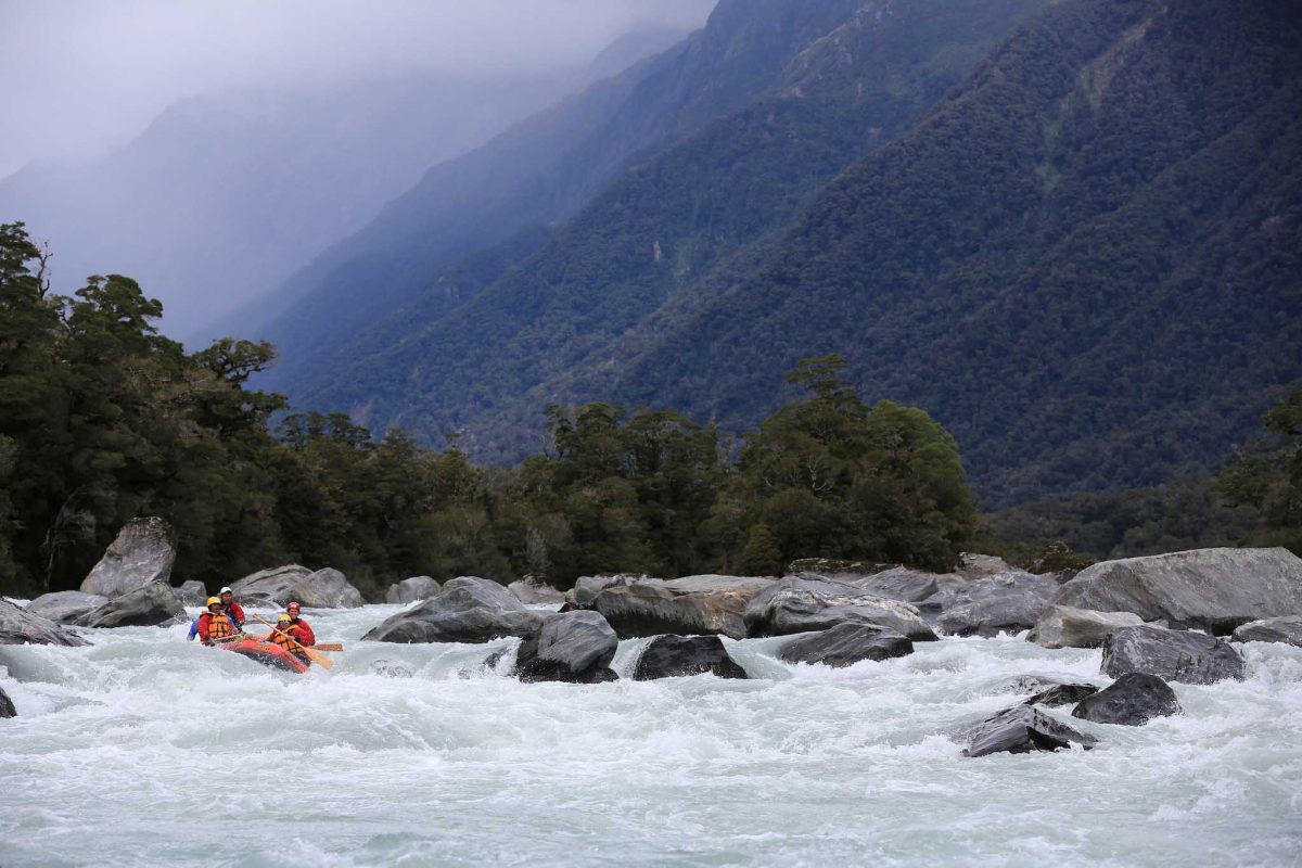Whitewater rafting a river between high mountains